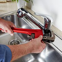 plumber working on a sink
